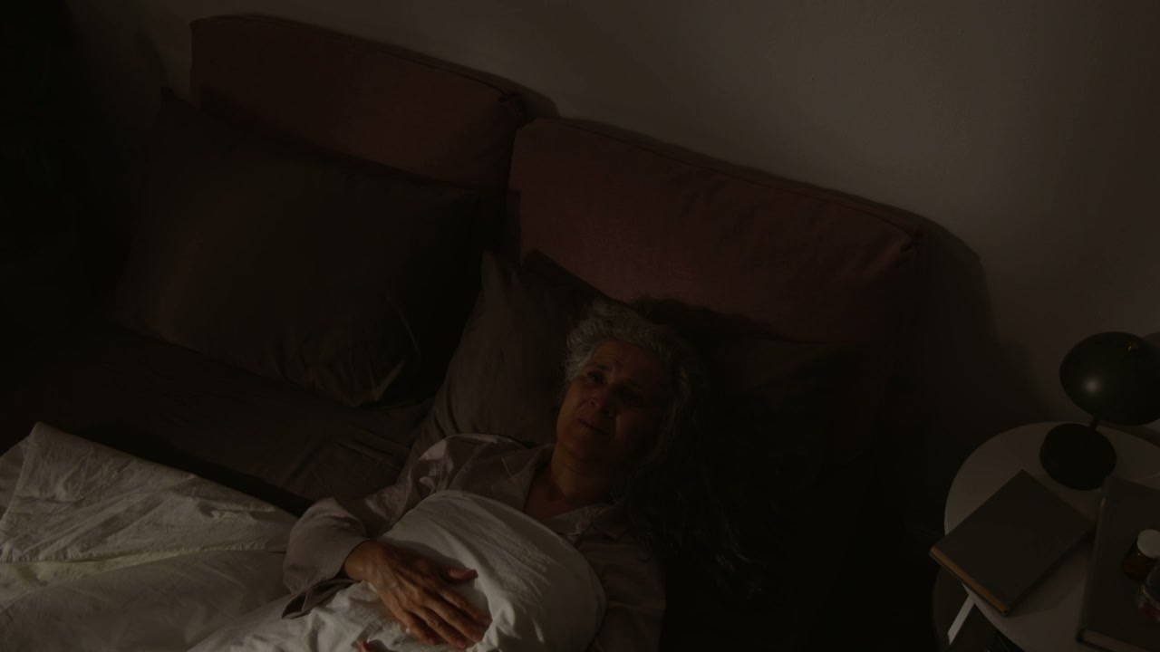 Elderly Woman Lying Awake in Bed at Night