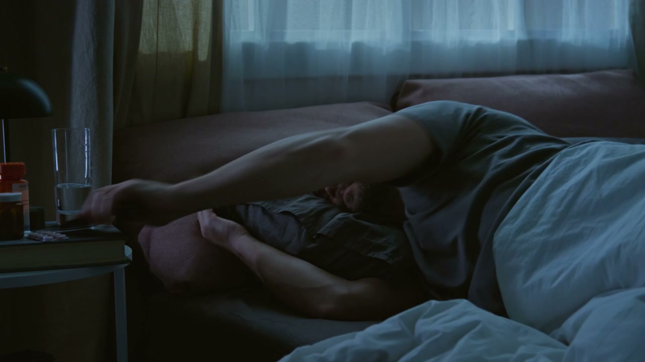 Man Struggling with Insomnia on Phone in Bed