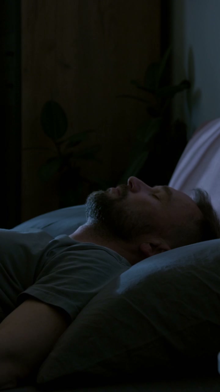 Restless Man Checking Smartphone in Bed
