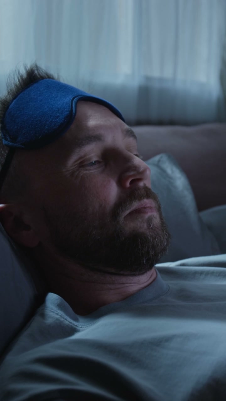 Man Resting in Bed with Sleep Mask