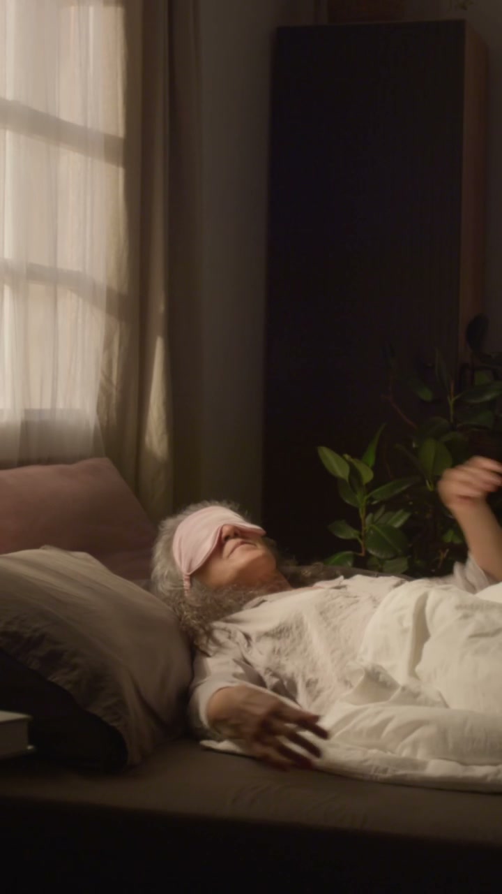 Senior Woman Sleeping in Bed With Eye Mask
