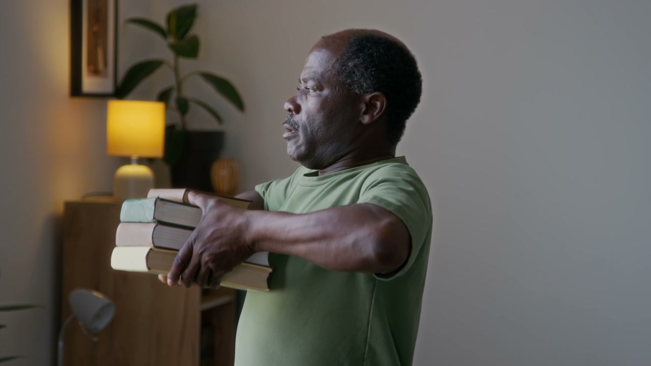 Senior Man Exercising with Books at Home