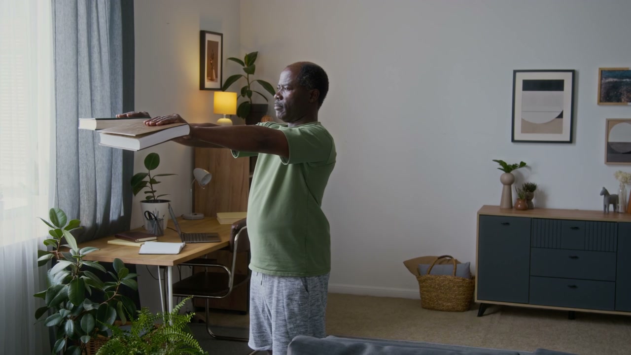 Senior Man Exercising with Books at Home