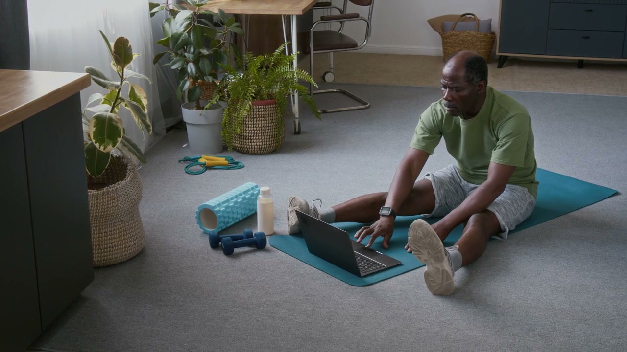 Senior Man Using Laptop for Home Workout
