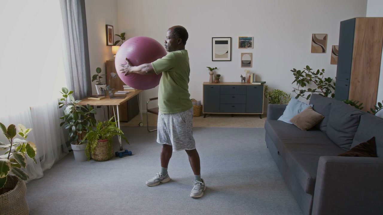 Senior Man Exercising with Ball at Home