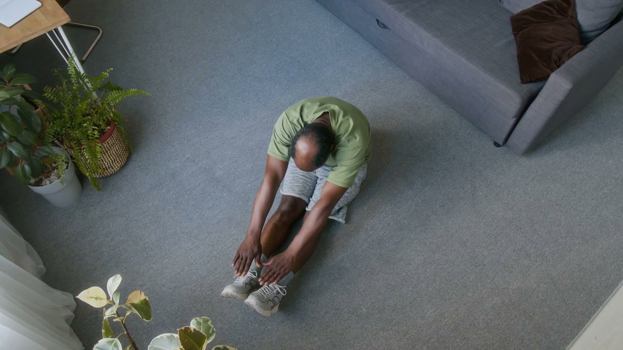Senior Man Doing Floor Stretches at Home