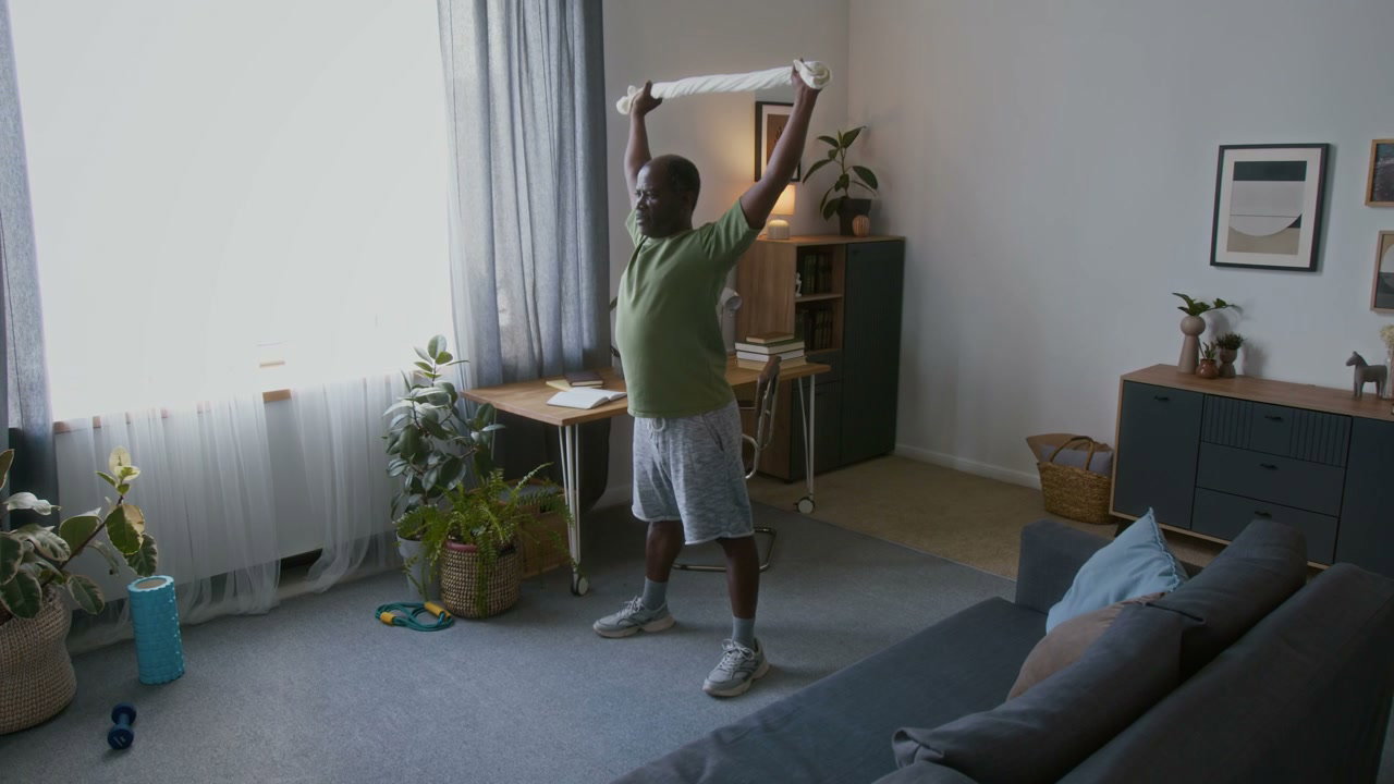 Senior Man Stretching with Towel at Home