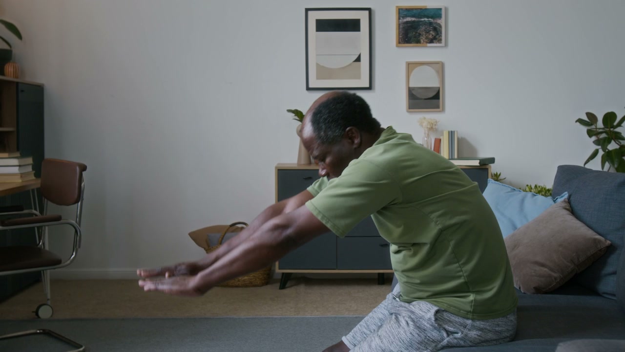 Senior Man Stretching Legs on Couch at Home