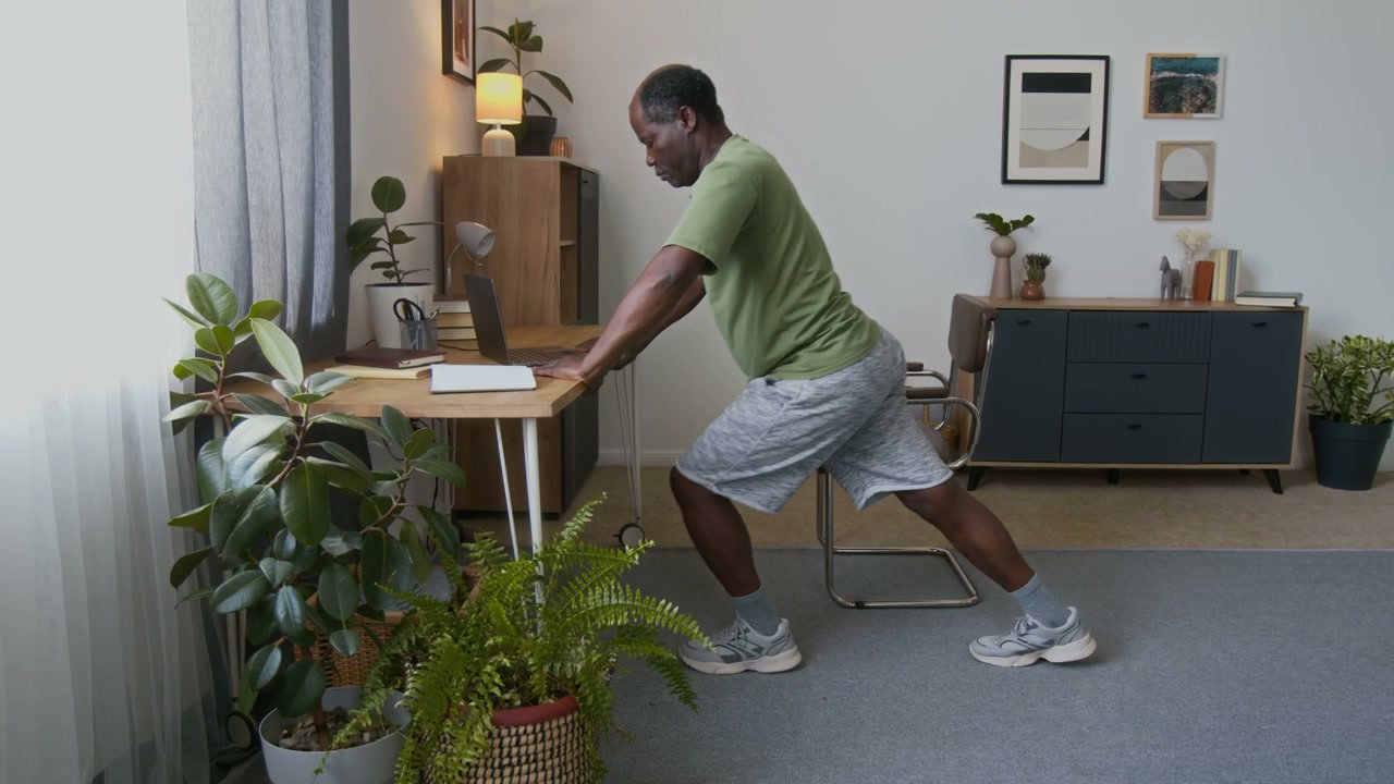 Older Man Exercising at Home Desk