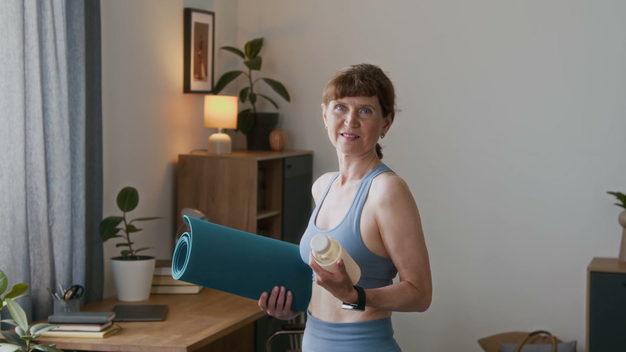 Smiling Senior Woman With Yoga Mat At Home
