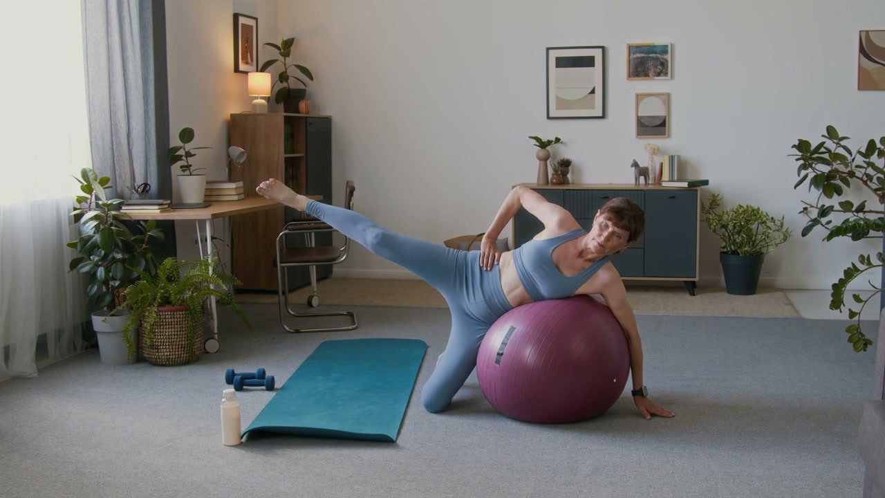 Senior Woman Doing Leg Raises with Stability Ball