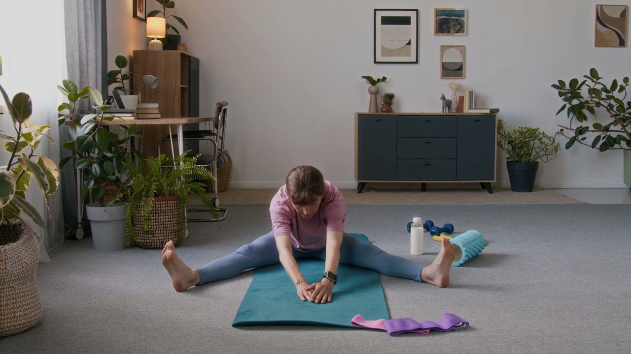 Senior Woman Stretching on Yoga Mat at Home