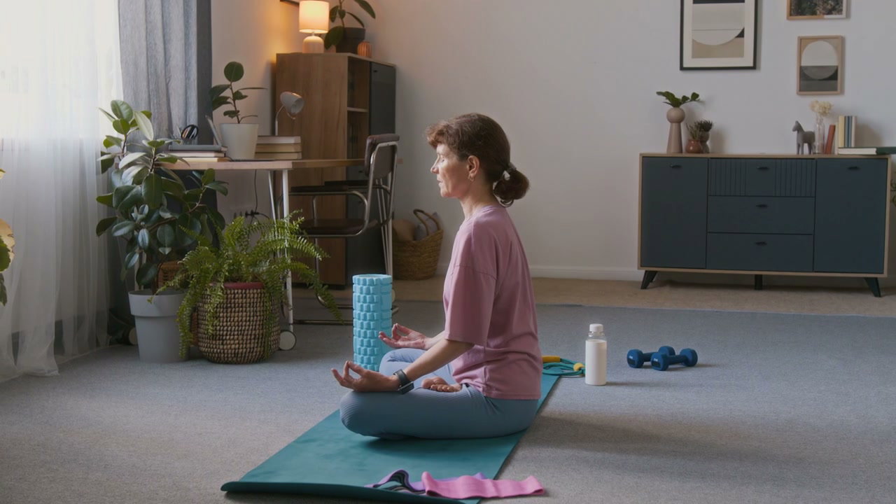 Senior Woman Meditating in Lotus Position at Home