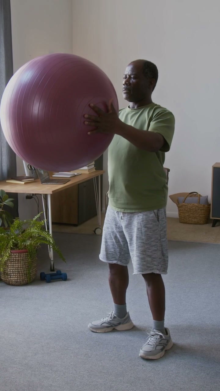 Elderly Man Doing Squats with Fitness Ball
