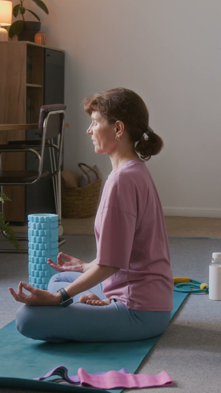 Senior Woman Meditating in Lotus Pose at Home
