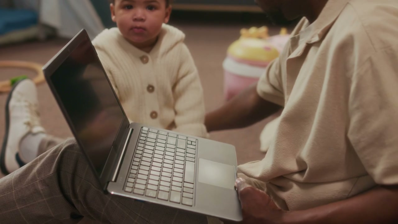 Father Working on Laptop with Baby
