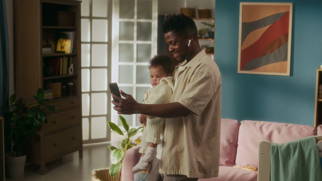 Father Holding Baby on Video Call at Home