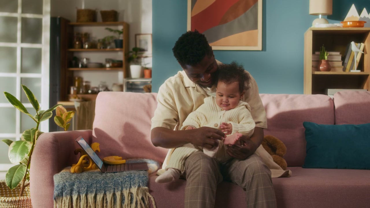 Dad And Baby Bonding In Living Room At Home