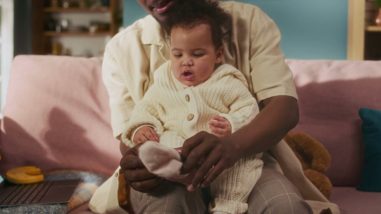 Dad Puts Sock on Baby's Foot