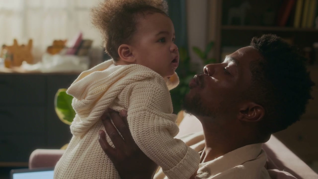 Father Kisses Baby While Playing at Home