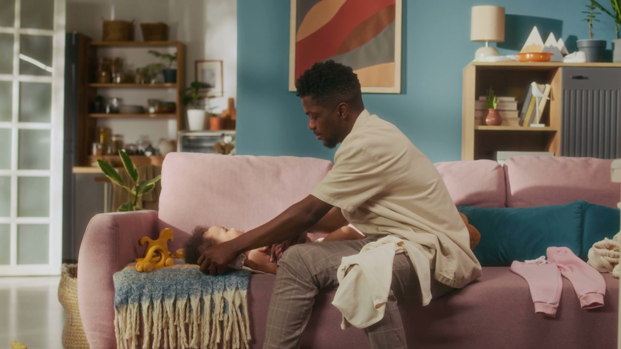 Dad Changing Baby's Outfit on Sofa