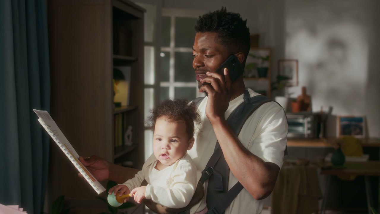 Father Multitasking with Baby and Phone Call