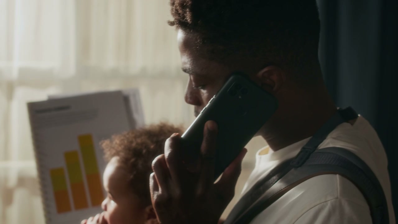 Father Multitasking on Phone with Baby