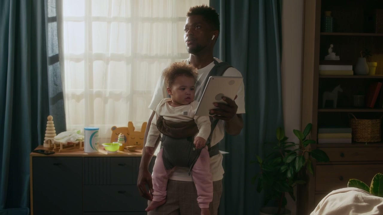 Father Working from Home While Carrying Baby