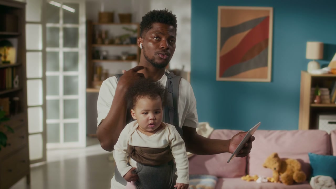 Dad Multitasking with Baby and Tablet
