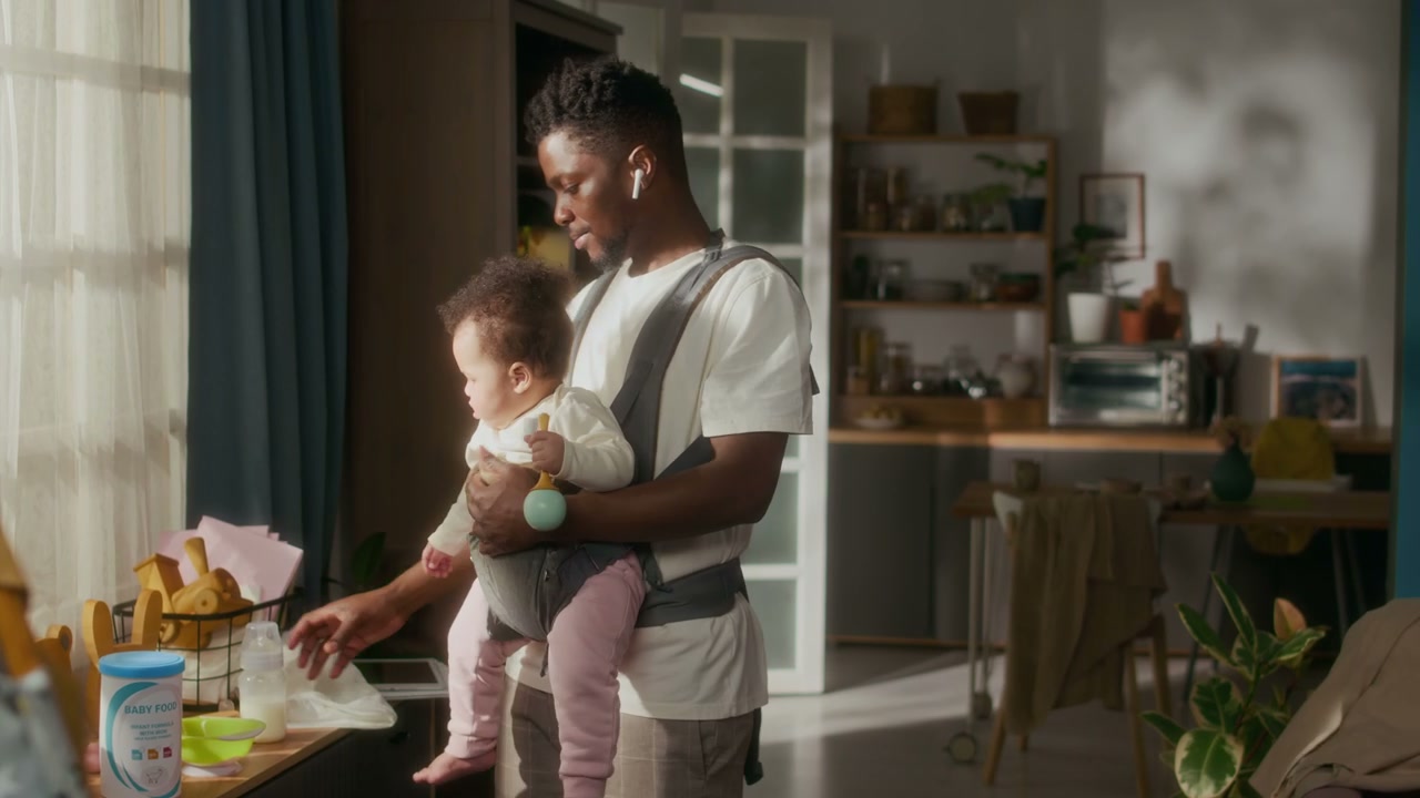 Father With Baby in Carrier Preparing Bottle