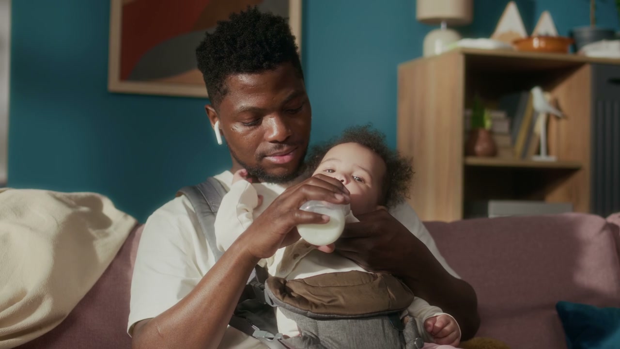 African American Dad Bottle Feeding Baby