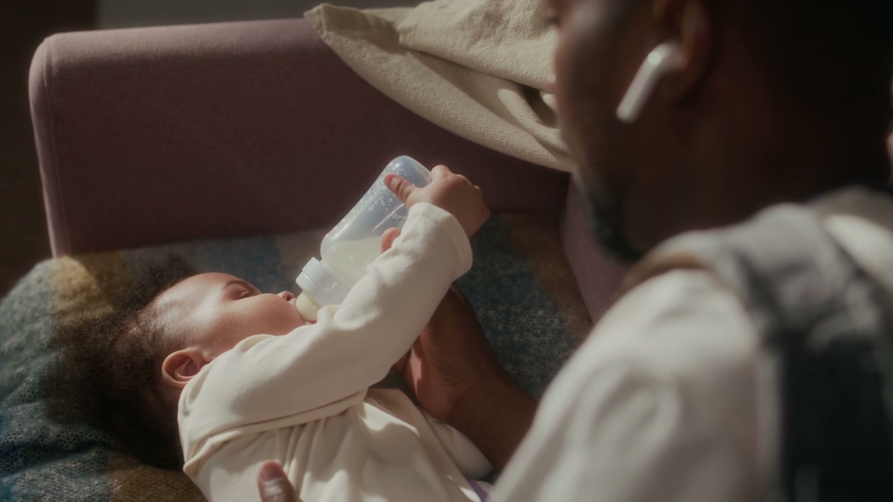 Dad Bottle Feeding Baby Girl at Home