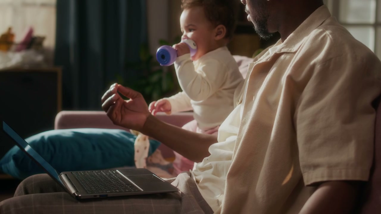 Father Works from Home with Baby