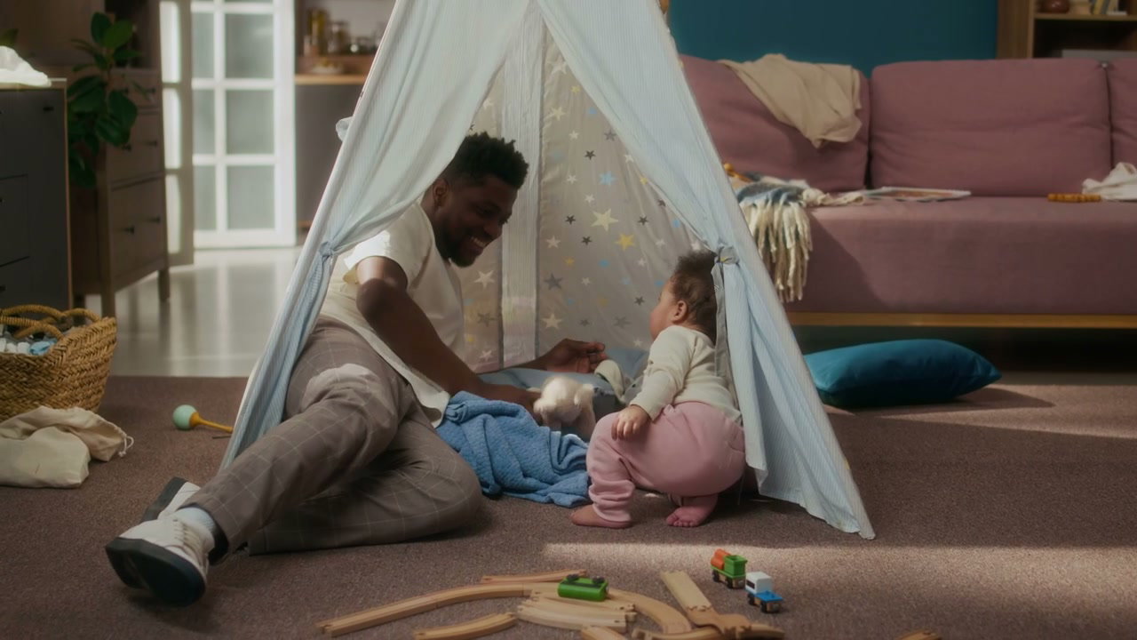 Happy Father and Baby Girl Play in Tent at Home