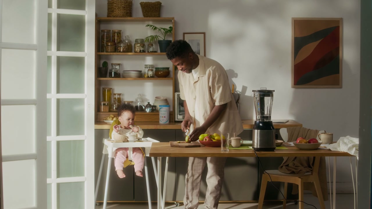 Father Chops Fruit for Baby in High Chair