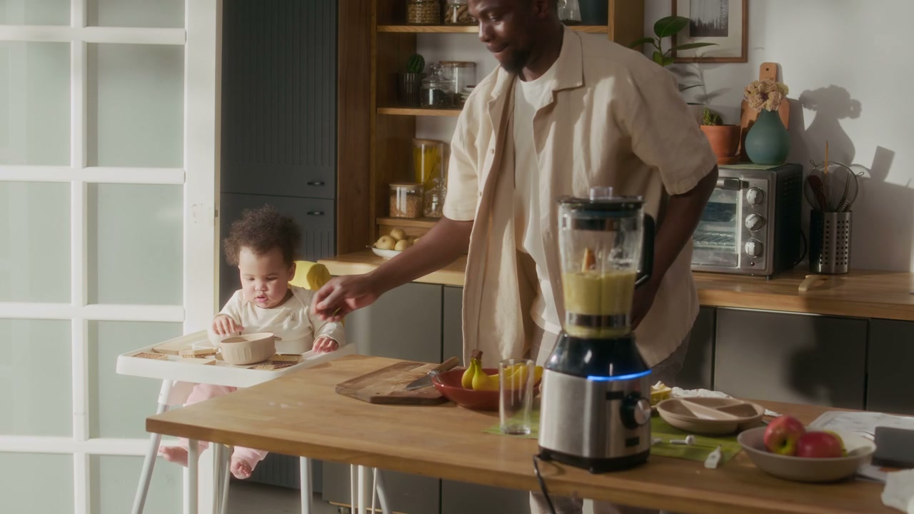 Father Makes Smoothie with Baby in Kitchen