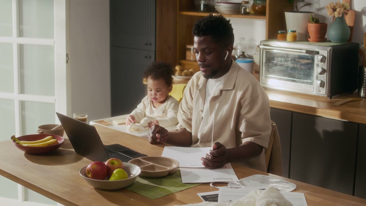 Father Works from Home with Baby in Kitchen