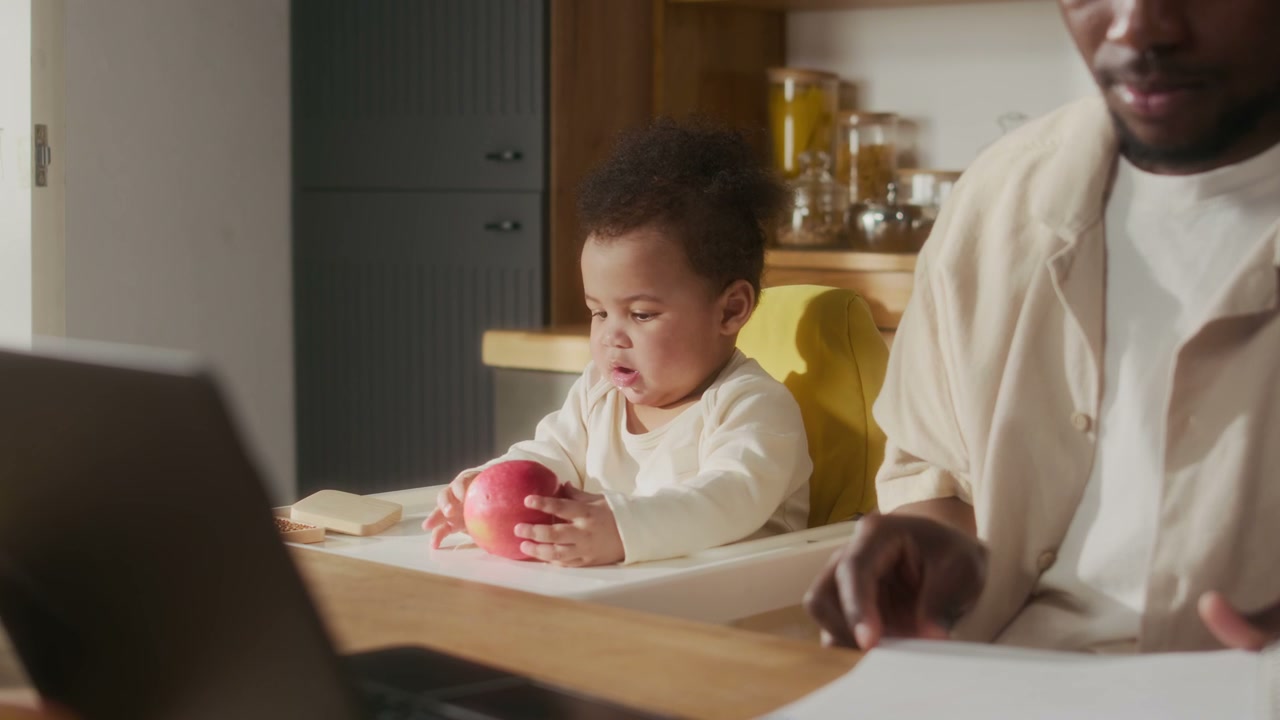 Father Working at Home with Baby in High Chair