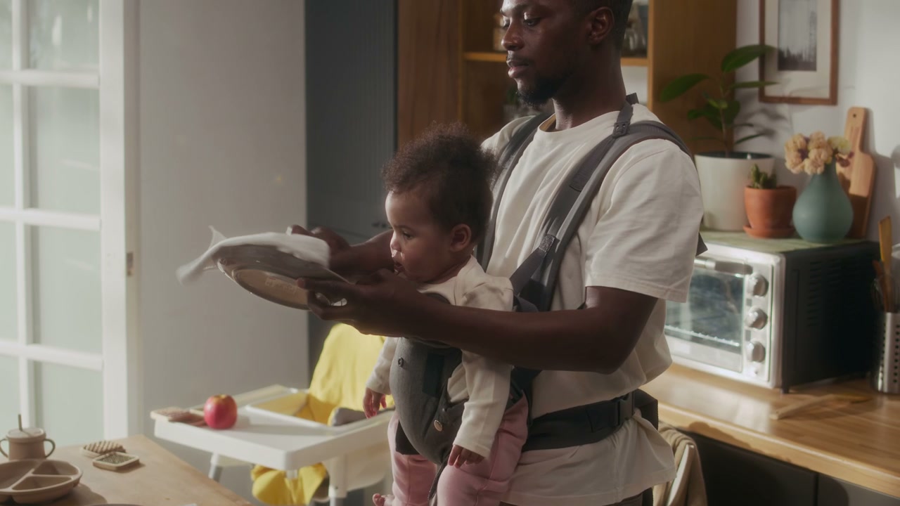 Father and Baby Drying Dishes in Kitchen