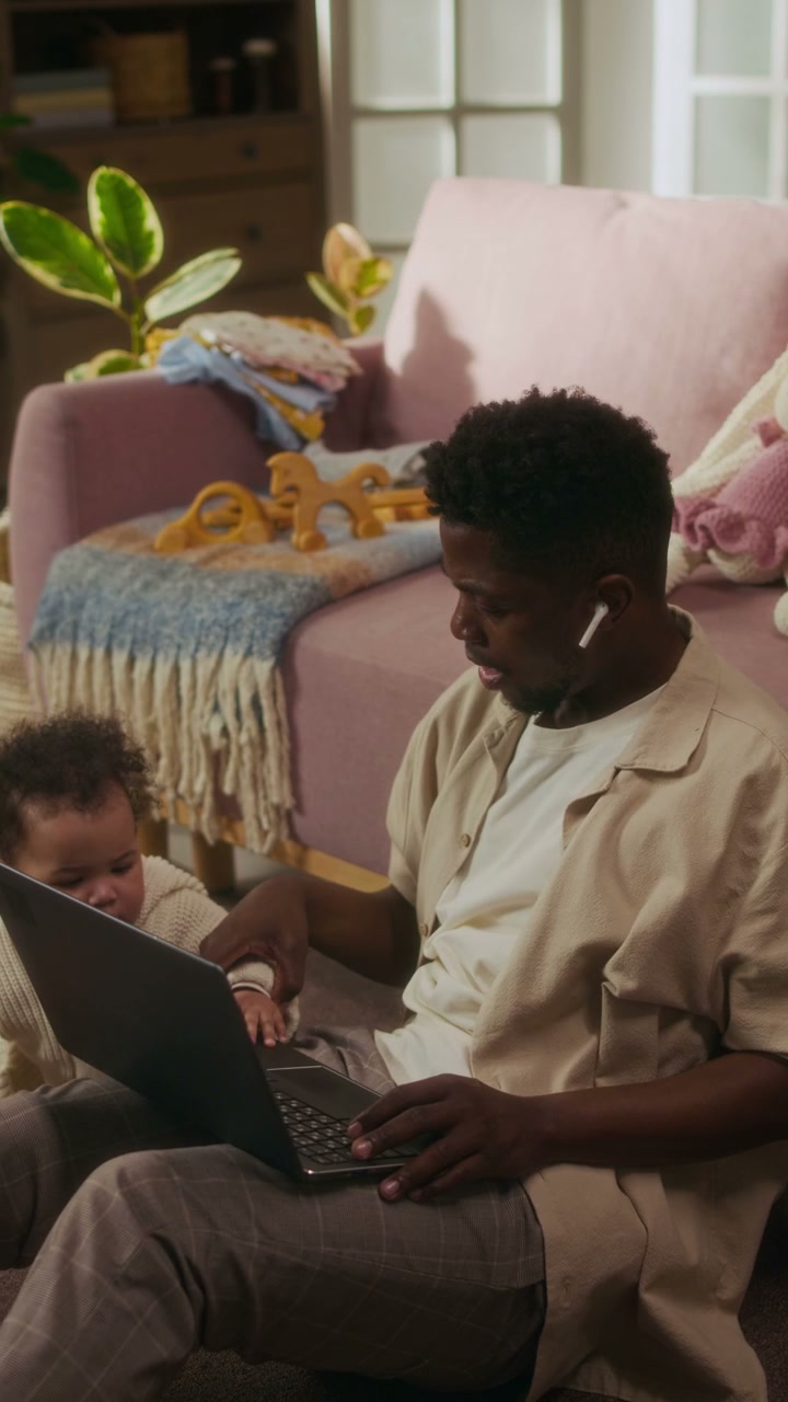 Father Working on Laptop with Baby at Home