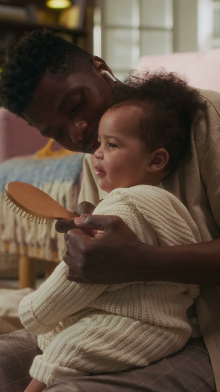 Father Brushing Daughter's Hair at Home