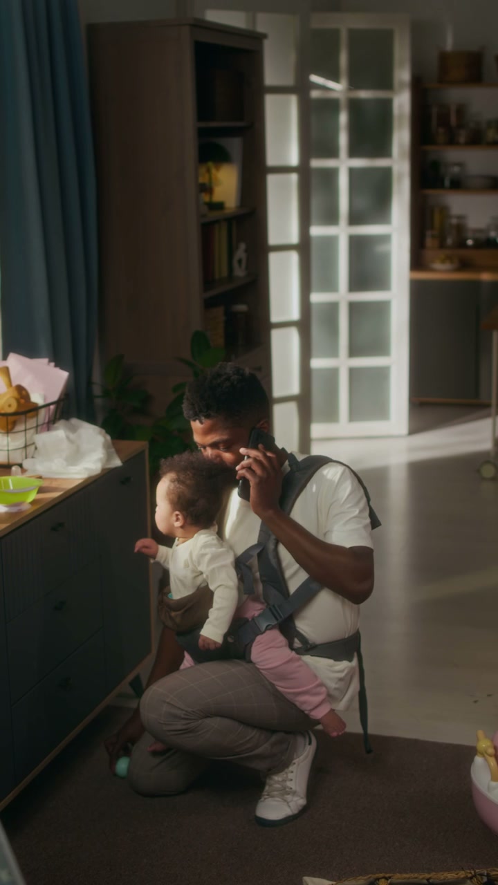 Father on Phone Call with Baby in Carrier