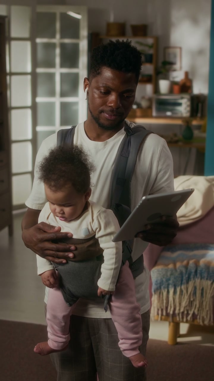 Man Babywearing While Using Tablet