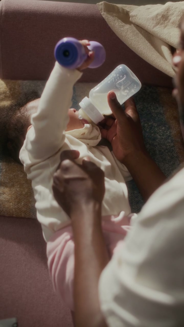 Father Bottle-Feeding Baby Girl