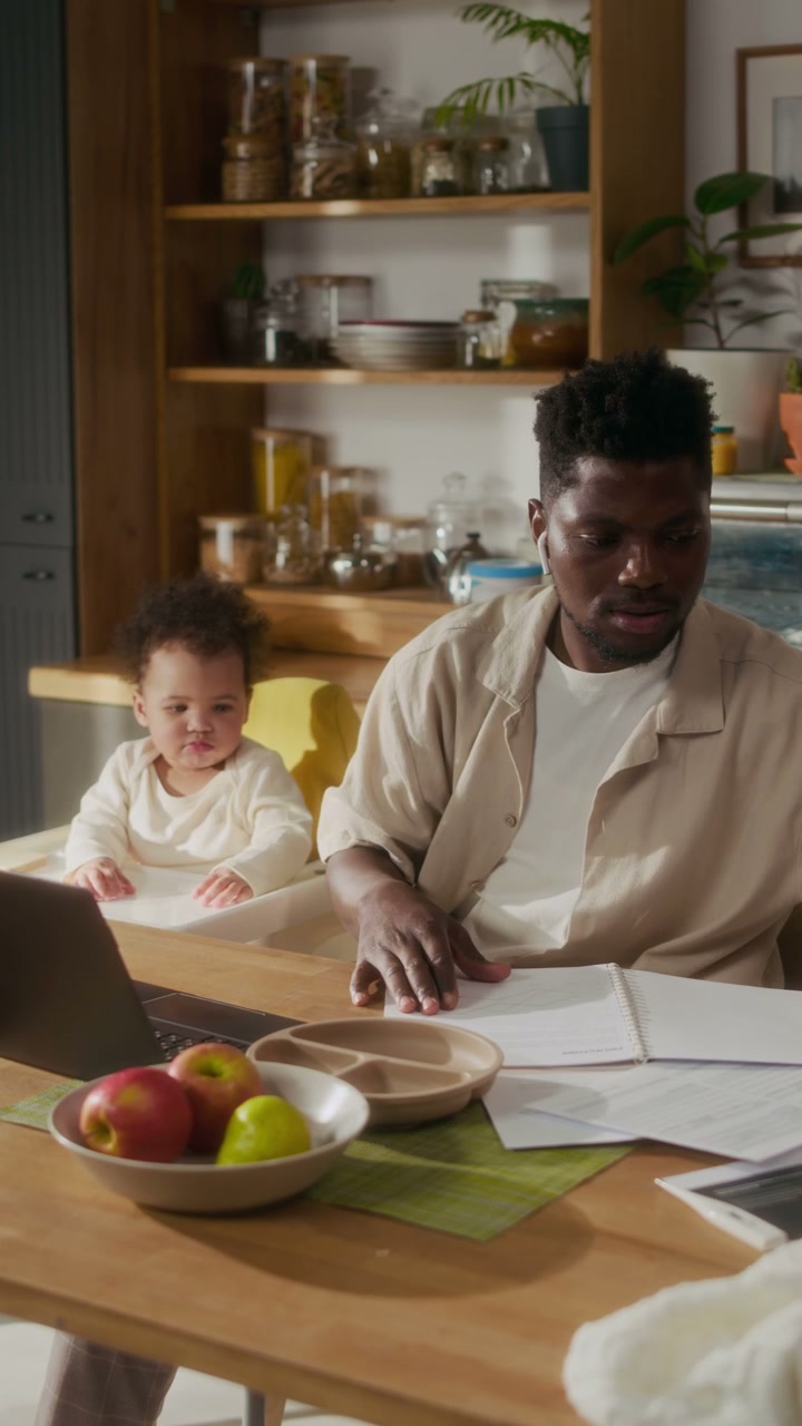 Father Working Remotely with Baby in Kitchen