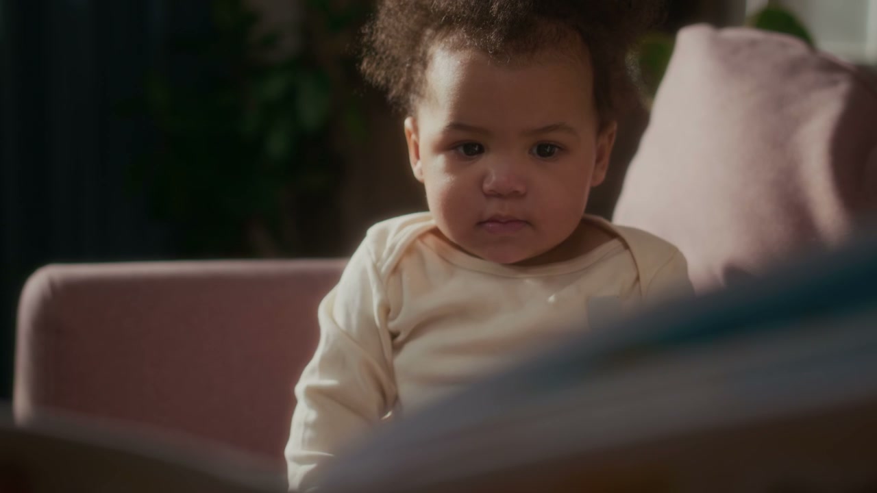 Curious Baby and Father Reading a Book