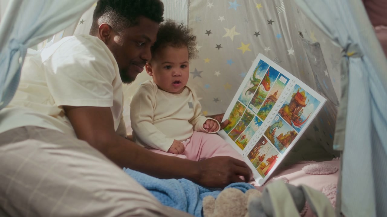 Father and Baby Reading Book in Play Tent