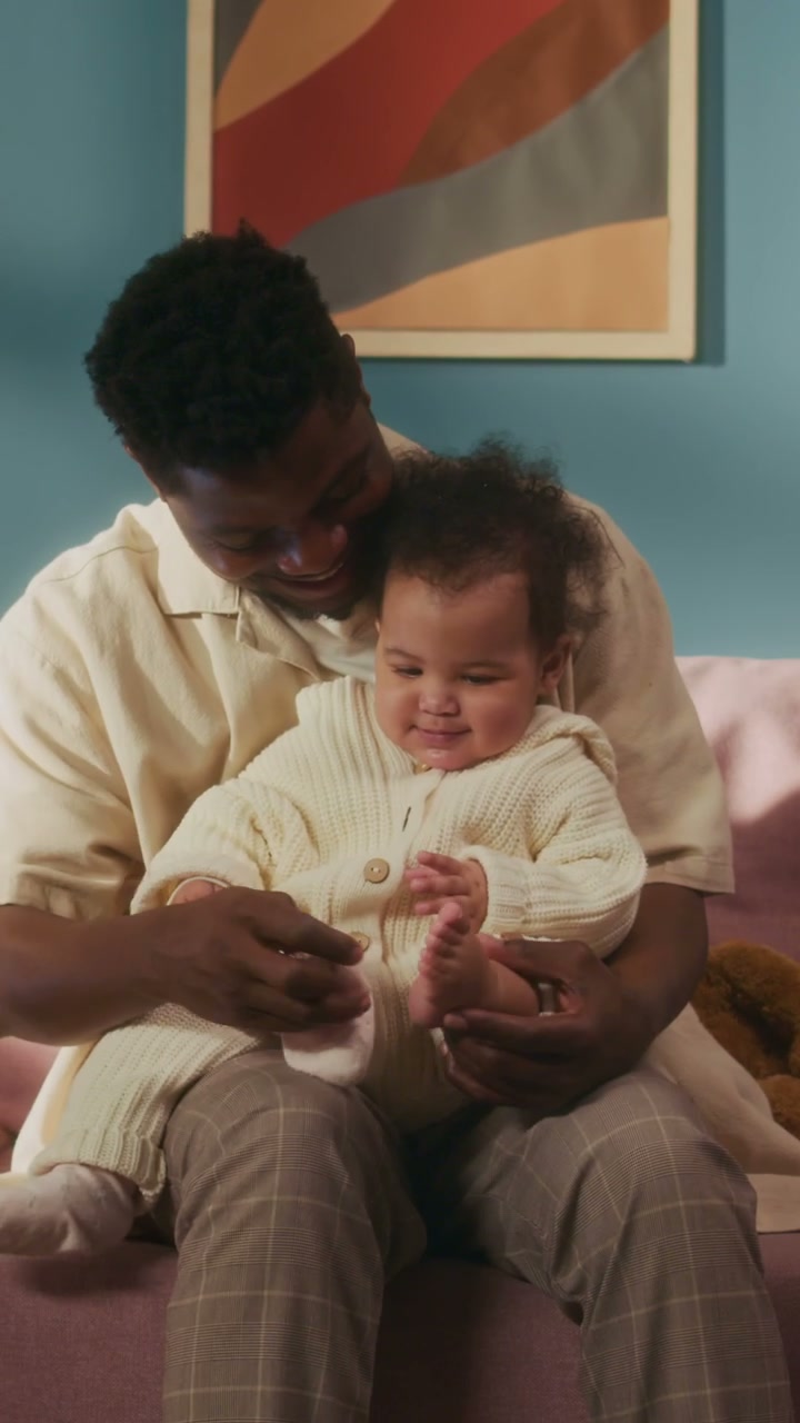 Dad Dressing Baby on Sofa