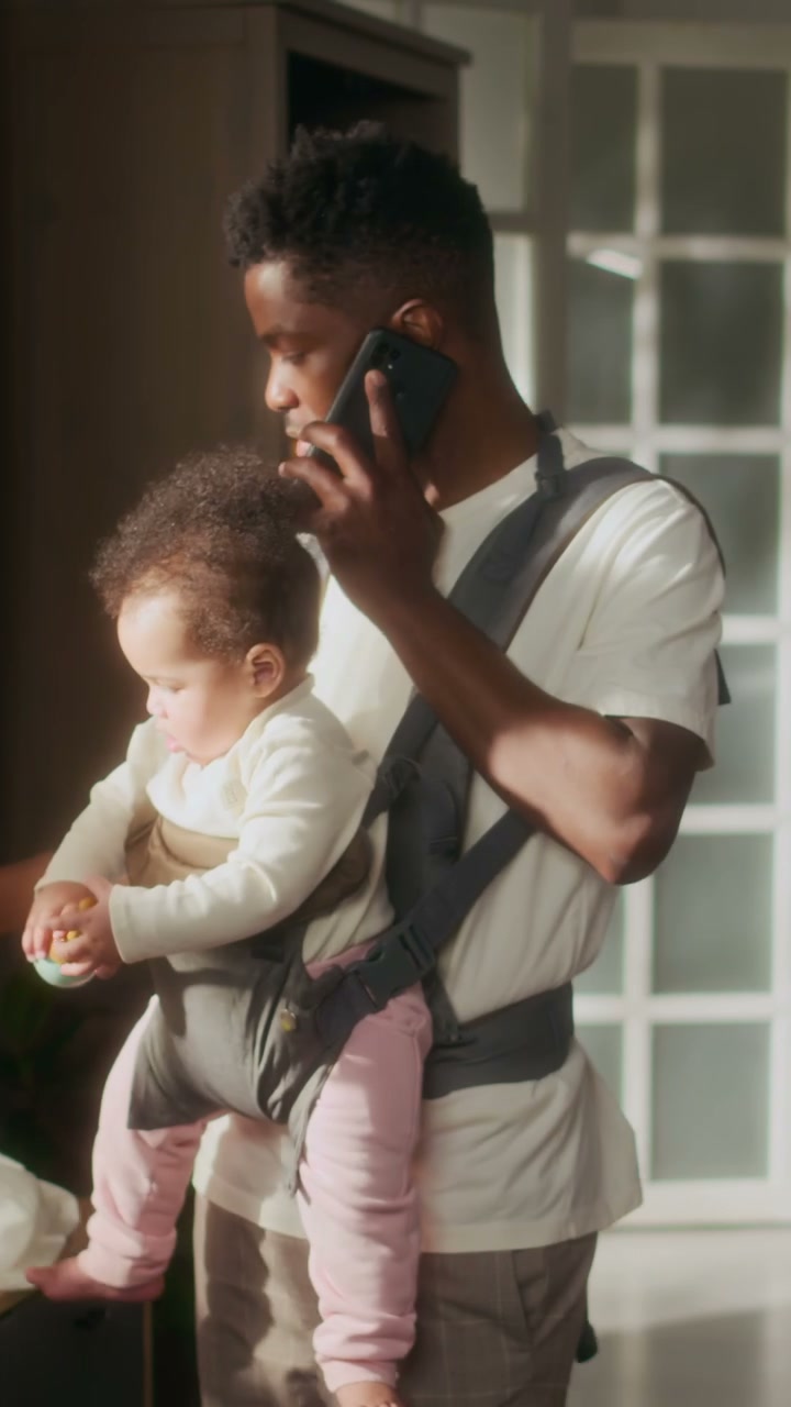 Father Multitasking with Baby and Phone Call