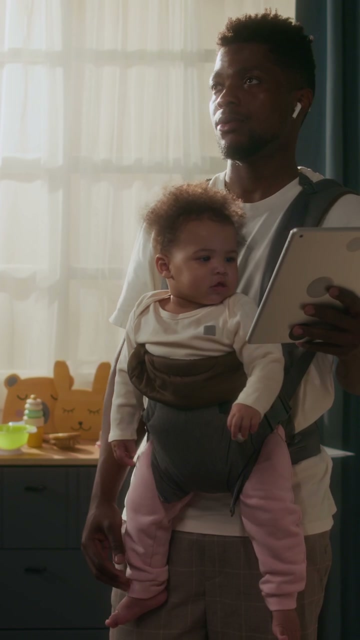 Father Multitasking with Baby and Tablet